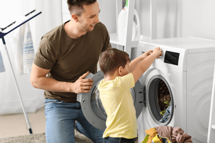 A father and son using a washing machine.