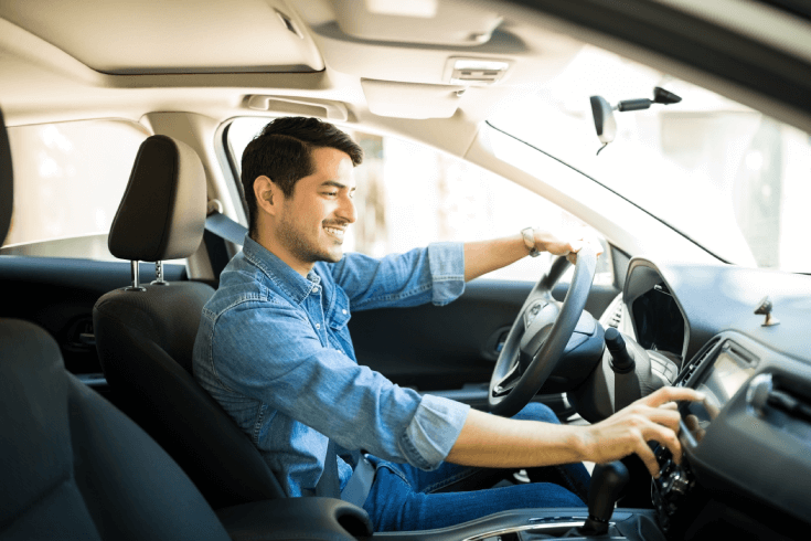 Image of a younger male driver tapping car display