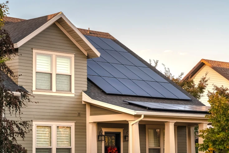 Grey two storey home with solar panels on roof.