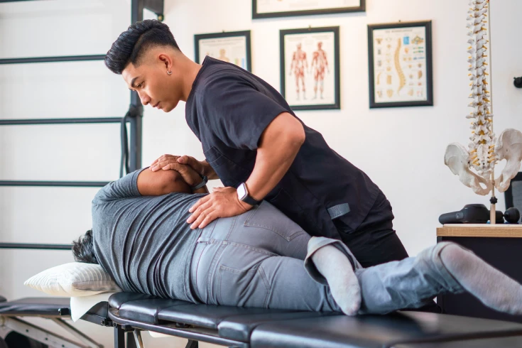 Masseur performing remedial massage in a clinic