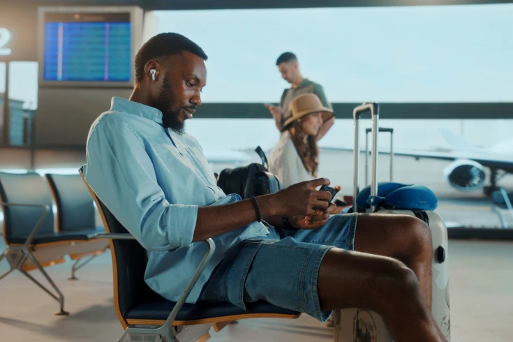 Traveler looking at phone while waiting at the airport lounge