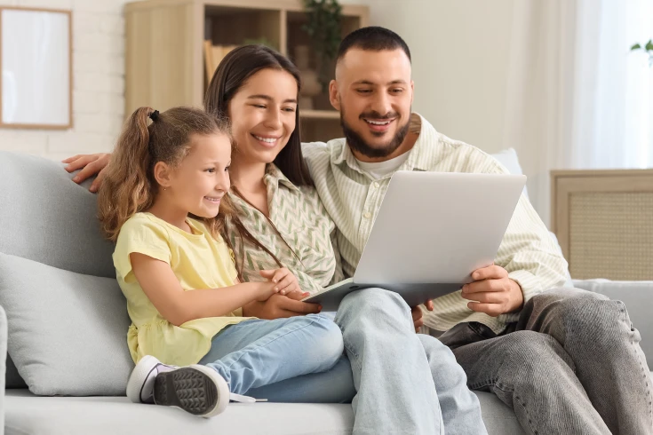 A family look over health insurance options together sitting on their couch