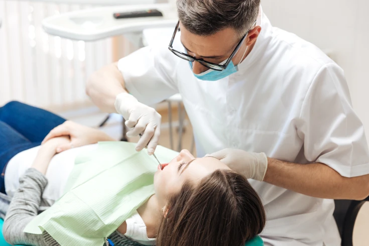 Woman in the dentist’s chair getting her wisdom teeth removed