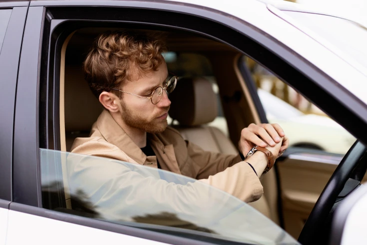 Image of a person in car looking at their watch