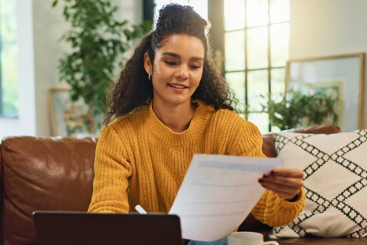 A young woman reads a private health insurance policy