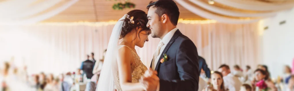 A married couple (female and male) dance together at their wedding.