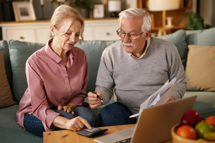 A couple use a calculate to figure out their lifetime health cover loading