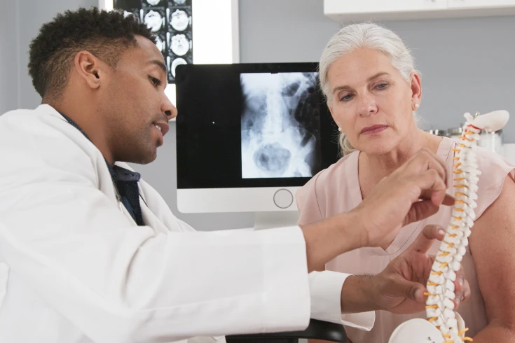 A doctor explains spinal fusion surgery to a patient