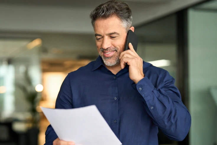 Man looking at his health insurance premiums while comparing options on the phone