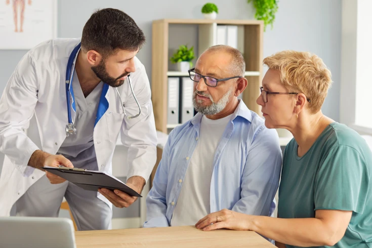 A doctor talks to a couple about what their health insurance covers