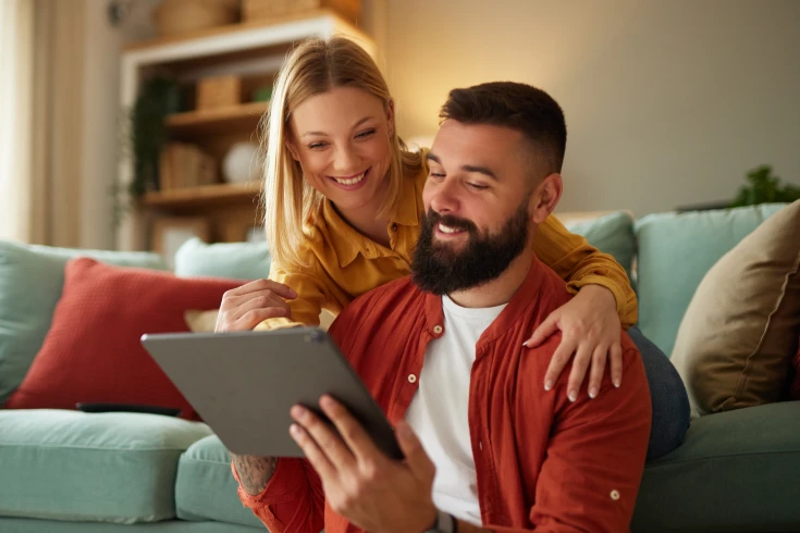 A young couple review health fund options on a digital tablet while at home