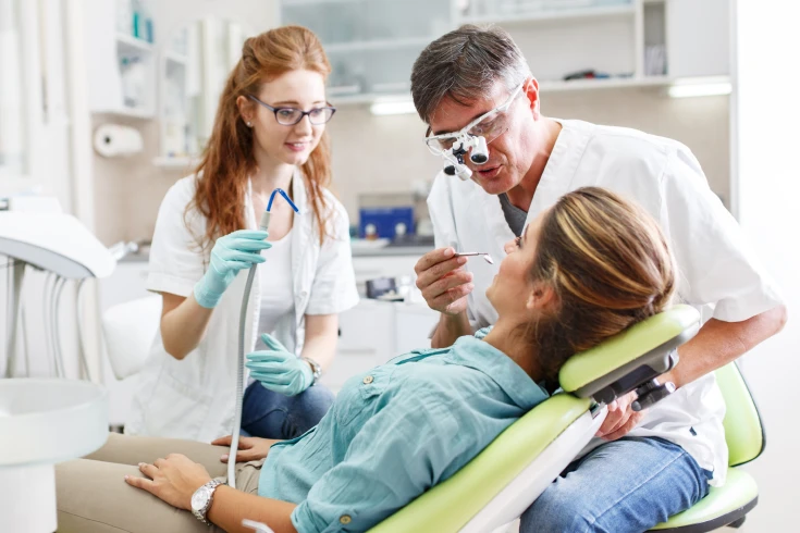 Patient undergoing a major dental procedure with a dentist and dental assistant
