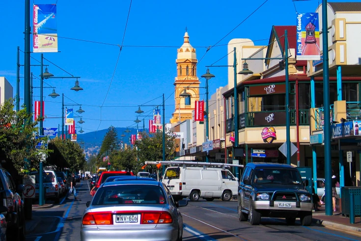 An image of cars on a street with buildings and a blue sky in the background.