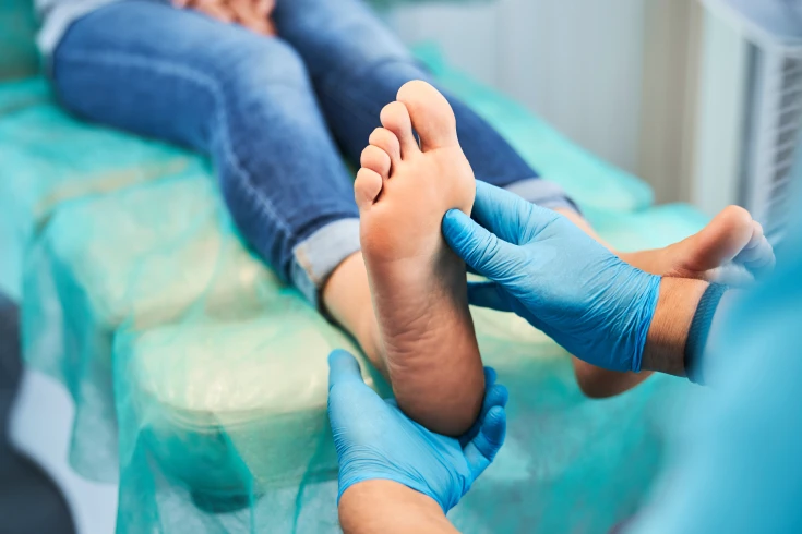 A podiatrist assesses a patient's feet for problems
