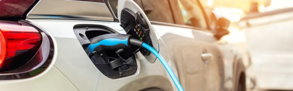 a close up of an EV charging with a blue power cable plugged in